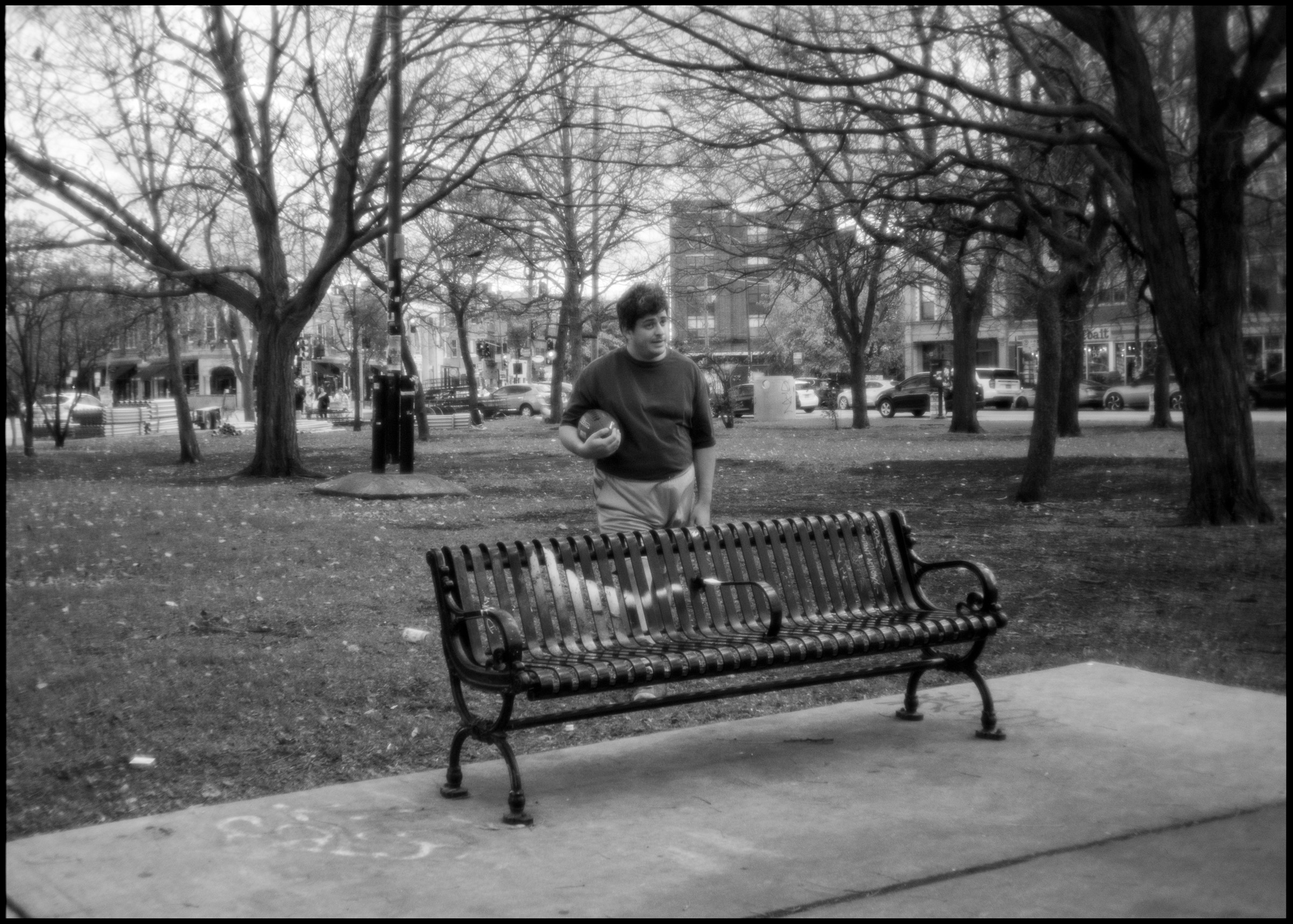 Person sitting by the monument with football, Logan Square Chicago 2024